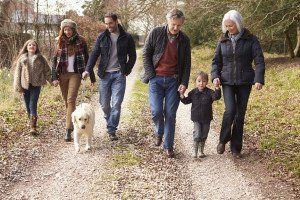 A family is walking a dog down a path.