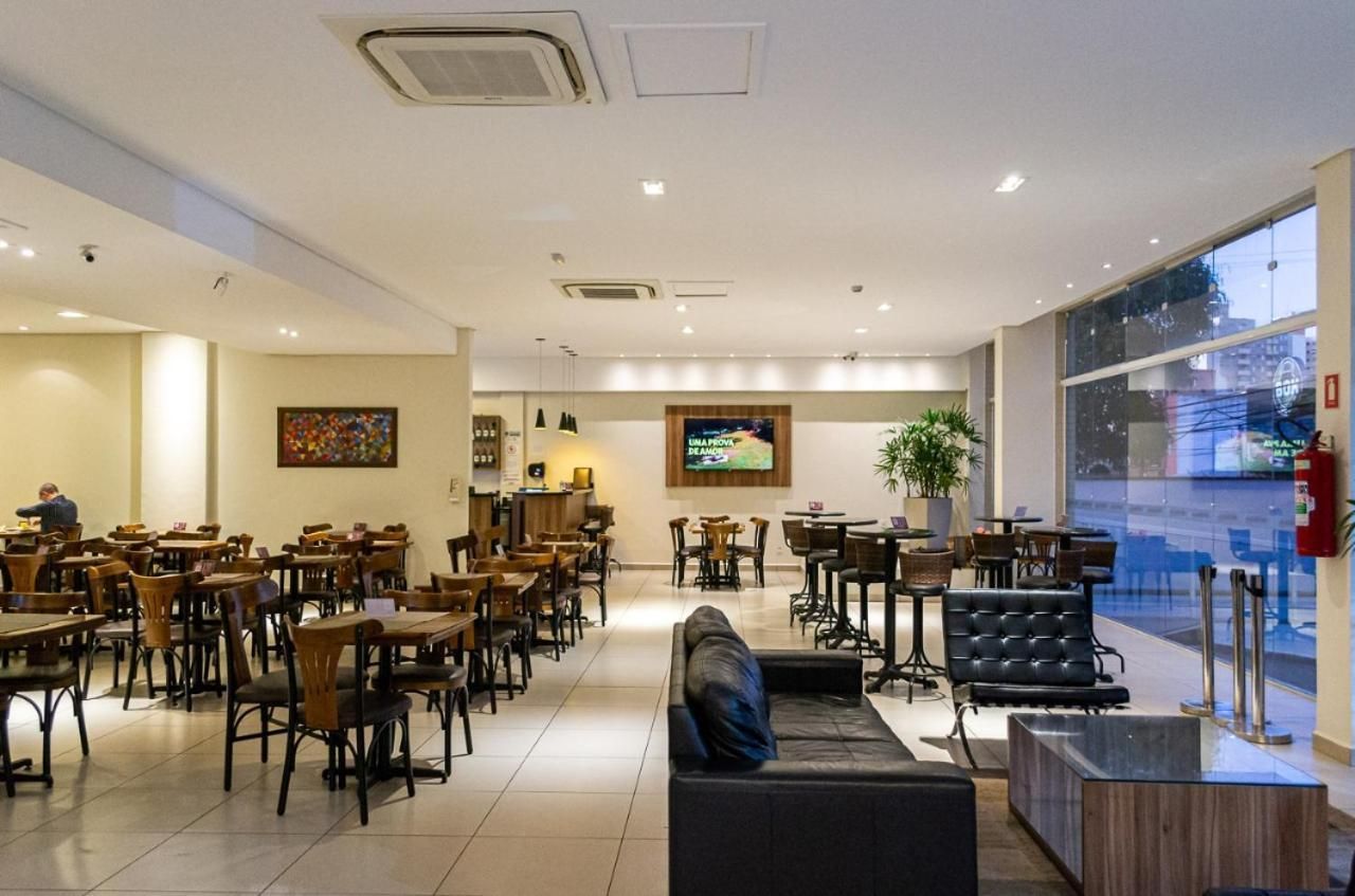 Uma sala grande com mesas, cadeiras, um sofá e uma televisão.-hotel-malibu-inn