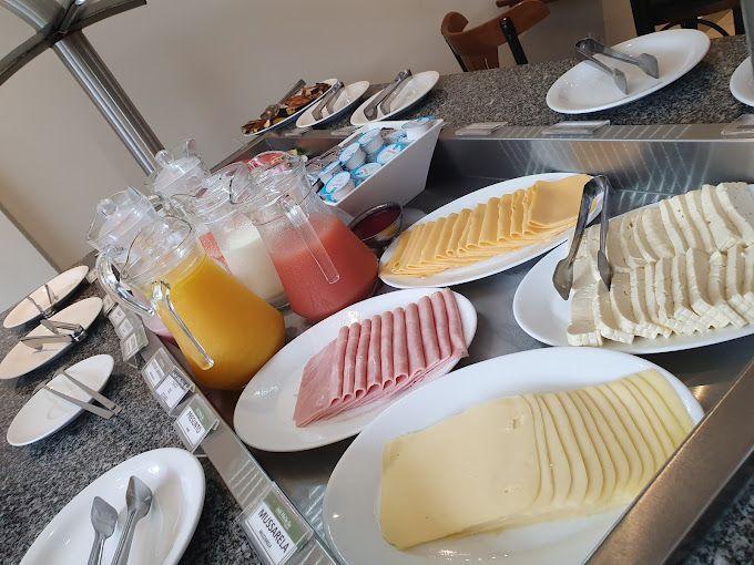 Uma mesa de bufê com pratos de comida e sucos-hotel-malibu-inn