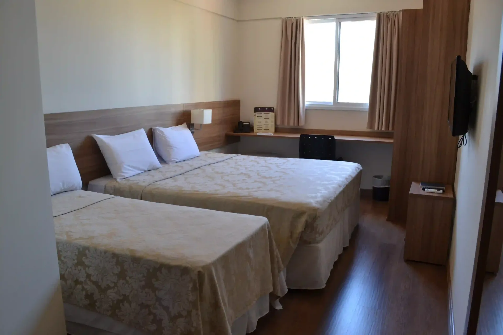 Um quarto de hotel com duas camas e uma janela.-hotel-malibu-inn