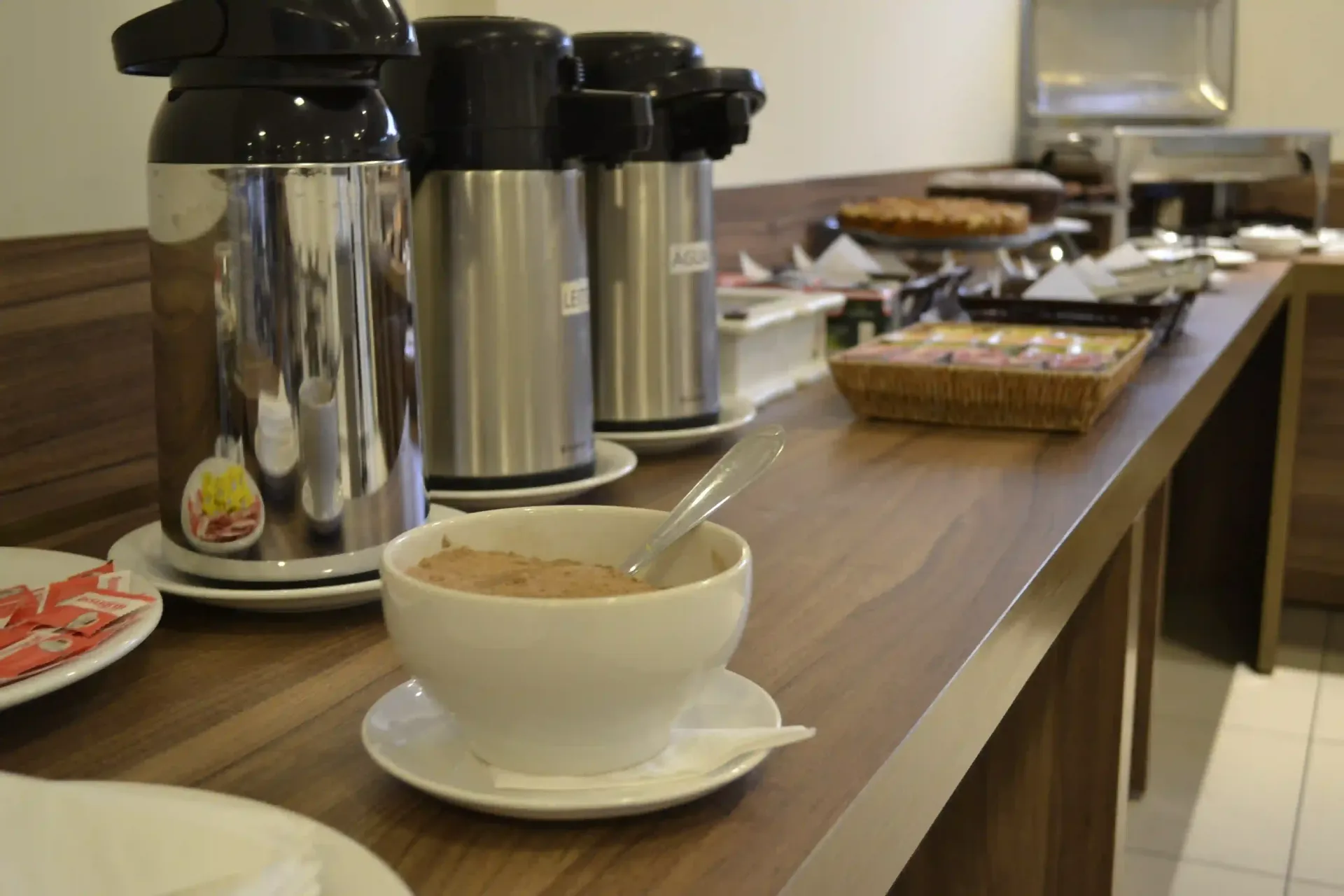 Uma xícara de café está em um pires sobre uma mesa-hotel-malibu-inn