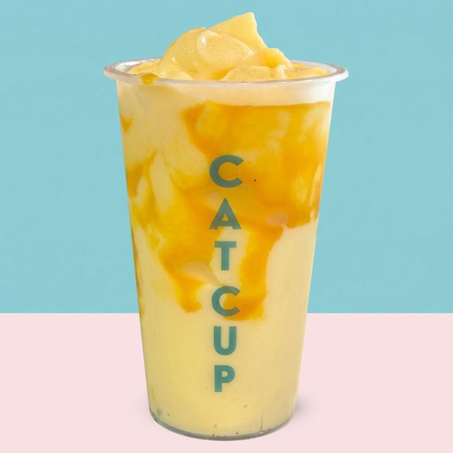 Cat Cup drink in a clear cup with yellow fruit chunks on a pastel background