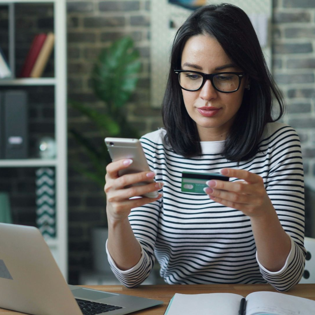woman with laptop and phone checking ID verifications