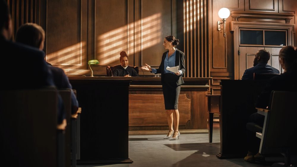 Woman in a Skirt Suit Speaks in a Courtroom — Hannaway Lawyers in Port Macquarie, NSW