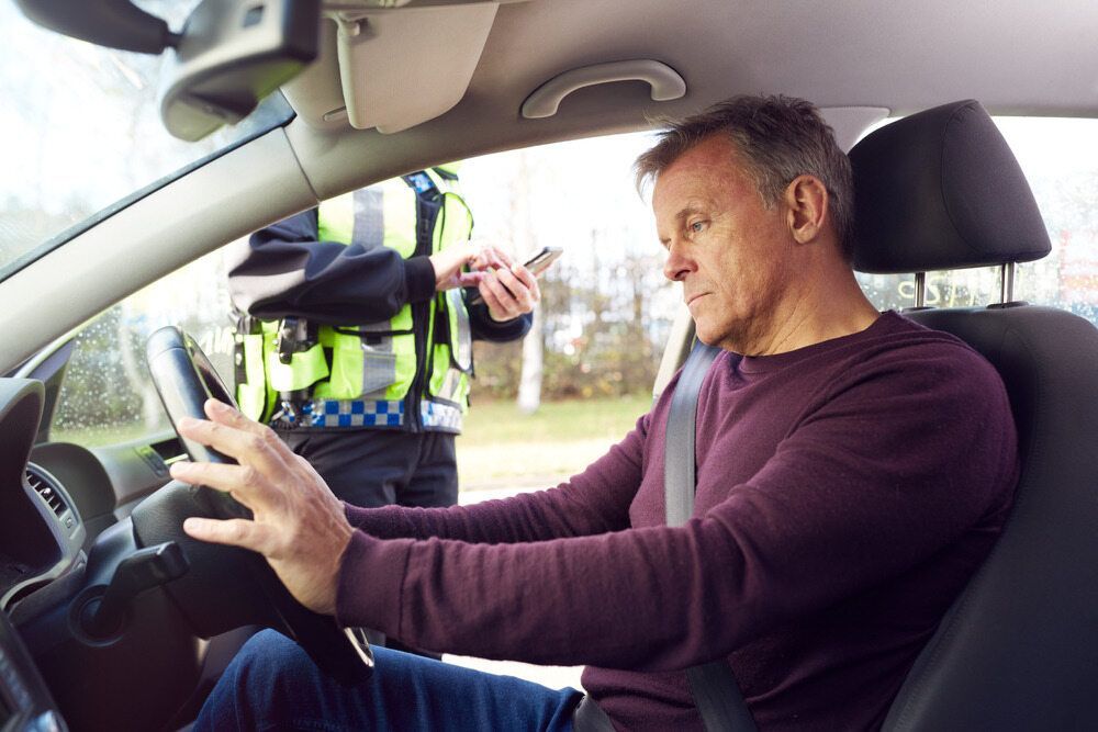 Man in Car Being Stopped by a Police Officer, the Officer is Taking Notes — Hannaway Lawyers in Port Macquarie, NSW