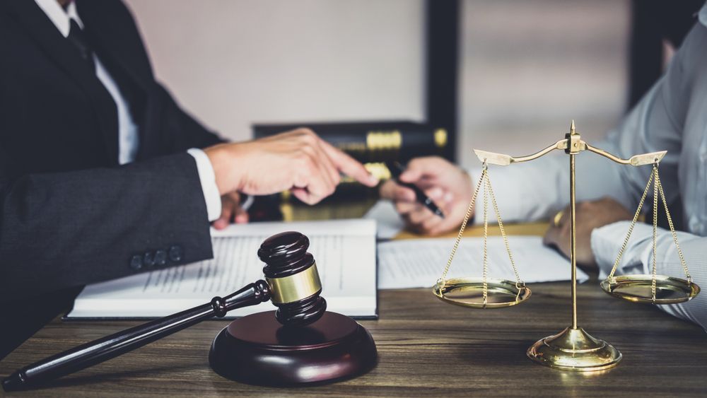 Lawyer And Clients Discussing Business Documents In Office
