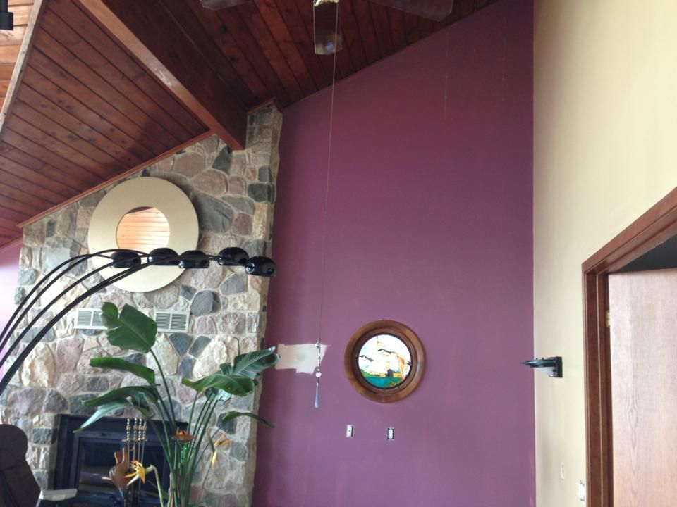 A living room with purple walls and a fireplace