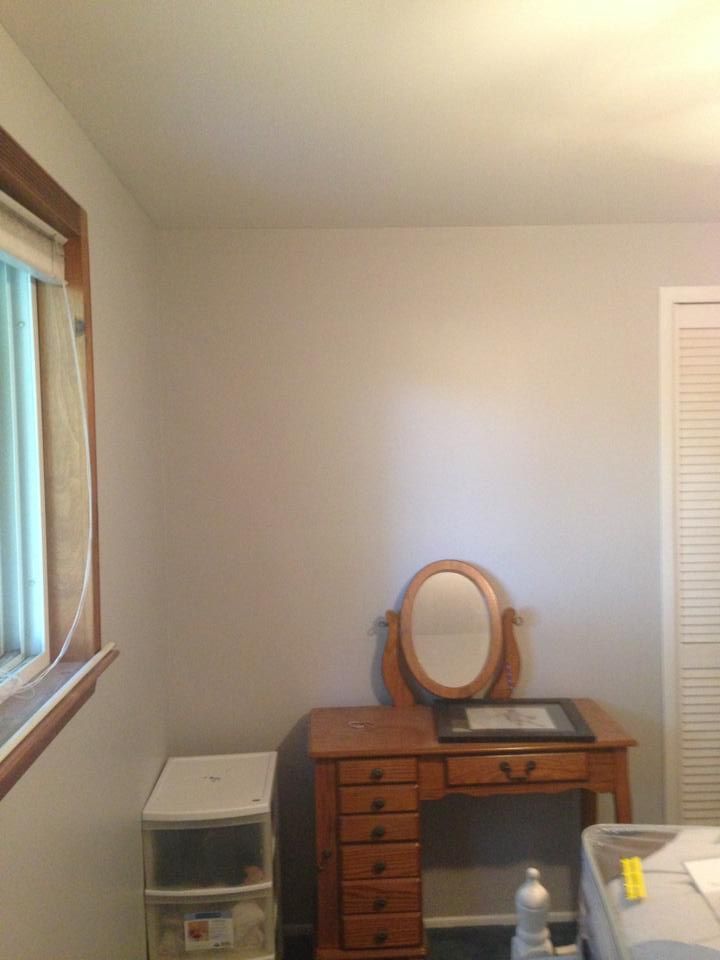 A room with a desk and a mirror in it