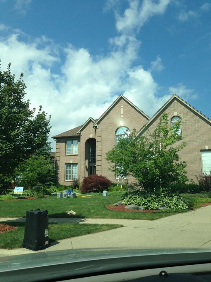 A large brick house with a blue sky in the background
