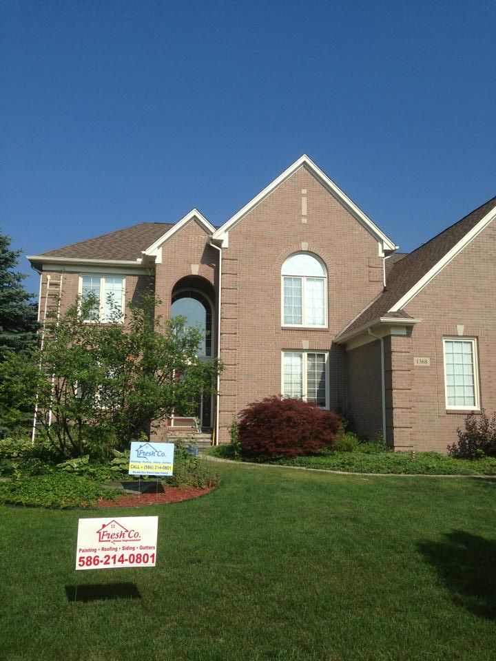 A large brick house with a for sale sign in front of it