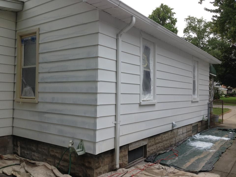 The side of a white house is being painted