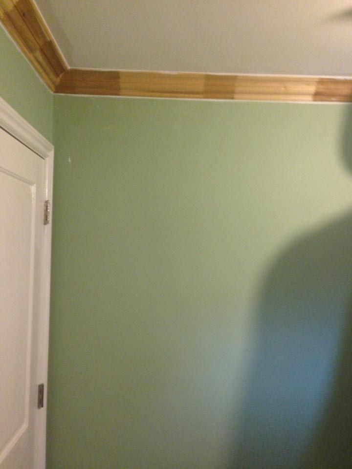 A room with green walls and a white door.
