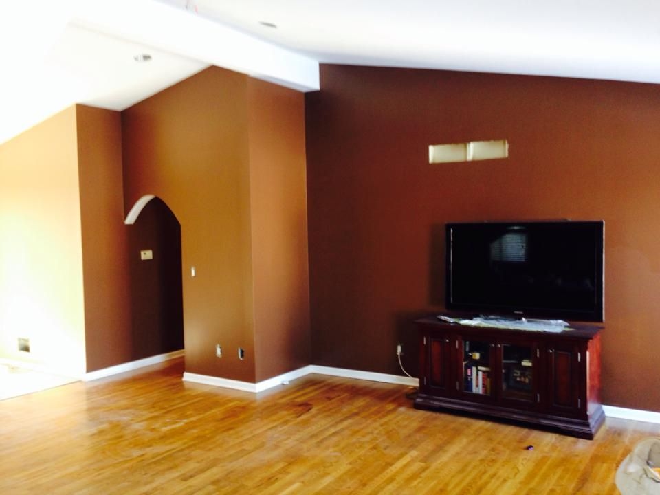 A living room with brown walls and a flat screen tv