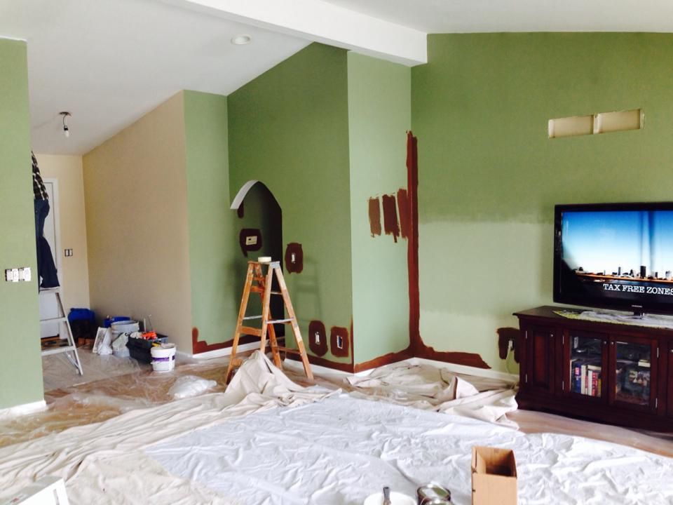 A living room with green walls and a flat screen tv