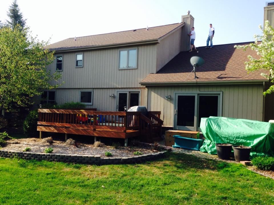 Two men are working on the roof of a house
