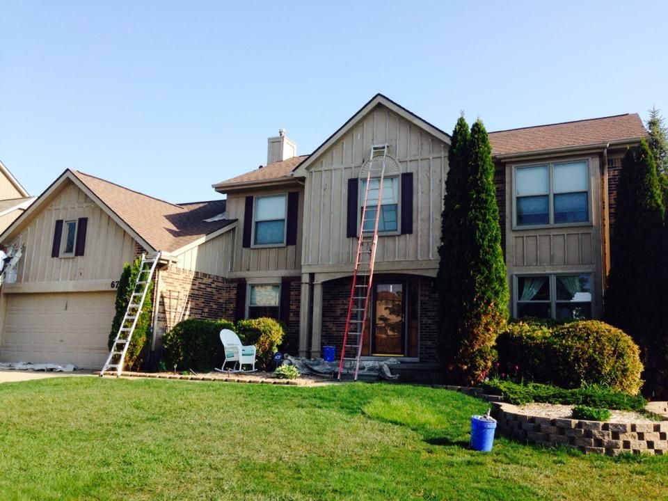 A house is being painted with a ladder in front of it