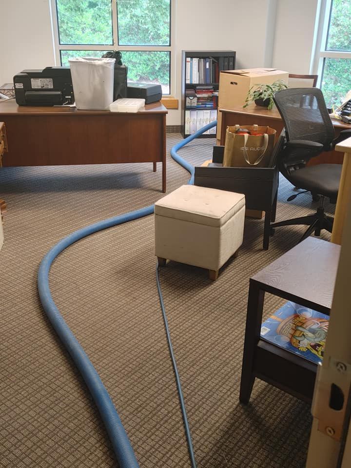 There is a hose in the middle of the room in the office.