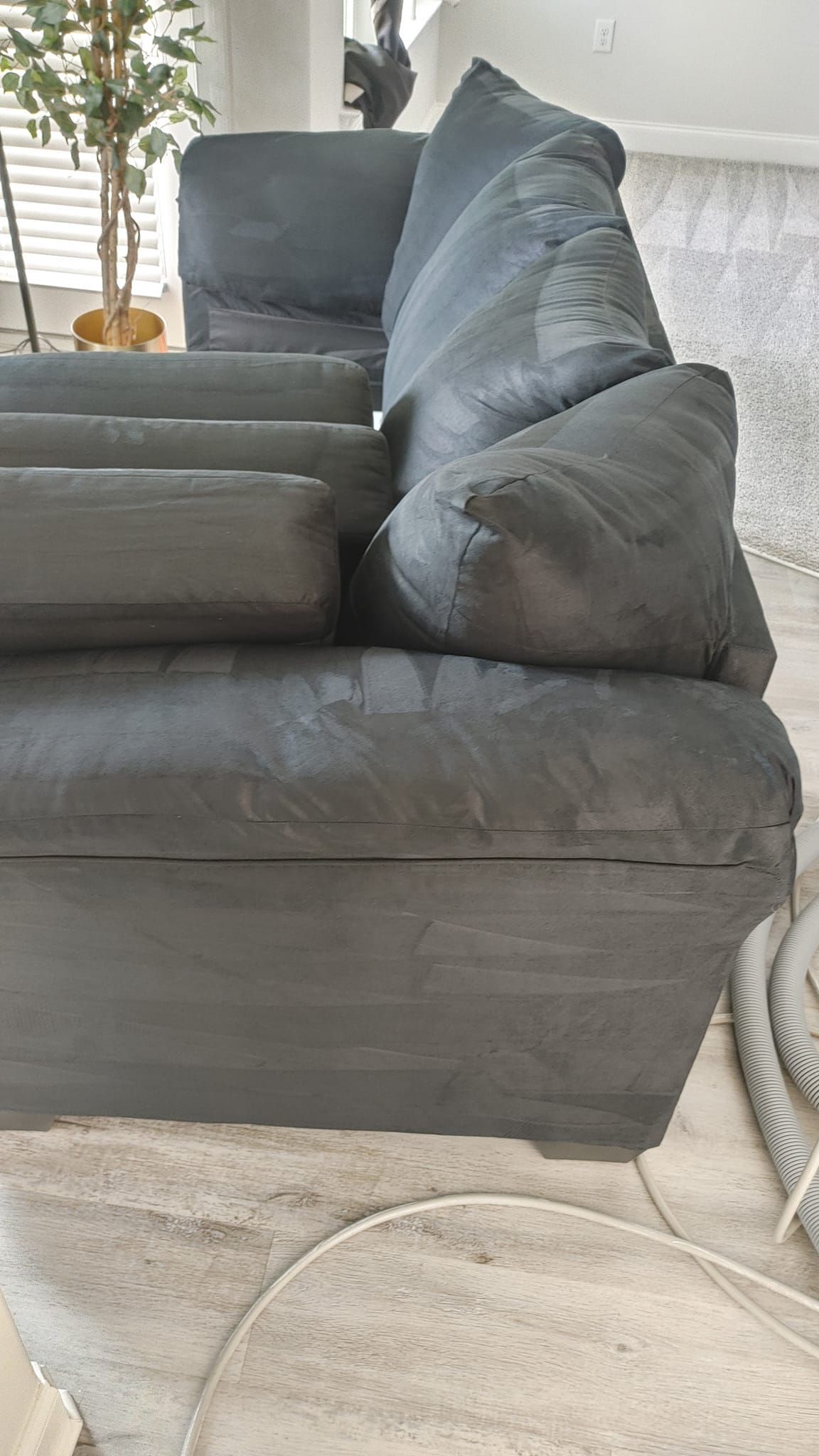 A gray couch is sitting in a living room next to a chair.
