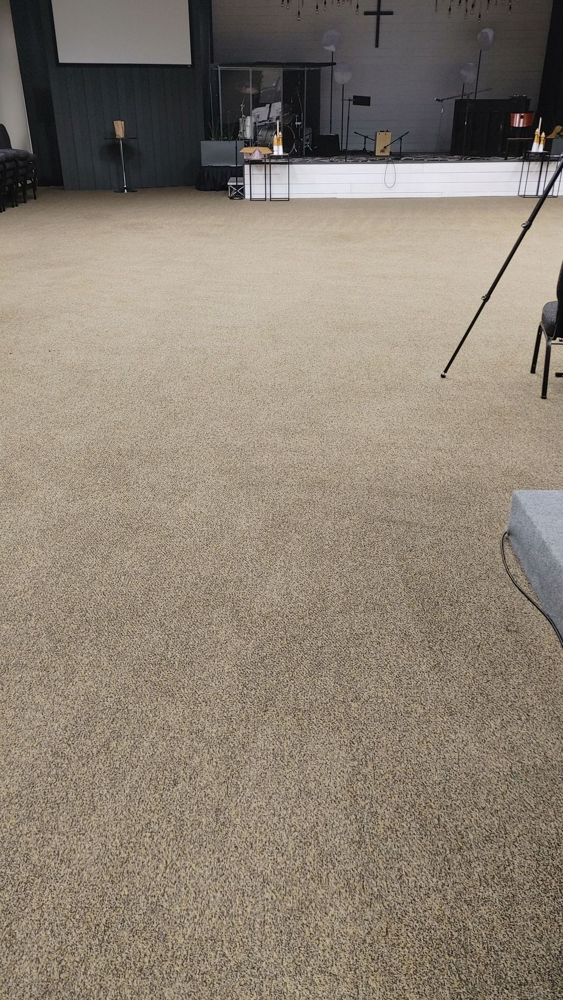 A vacuum cleaner is sitting on top of a carpeted floor in a room.