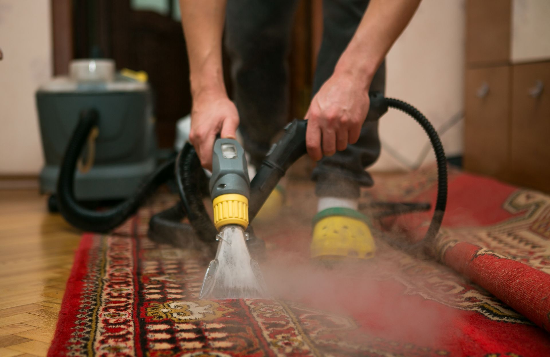 A yellow cord is laying on a tiled floor in a kitchen.