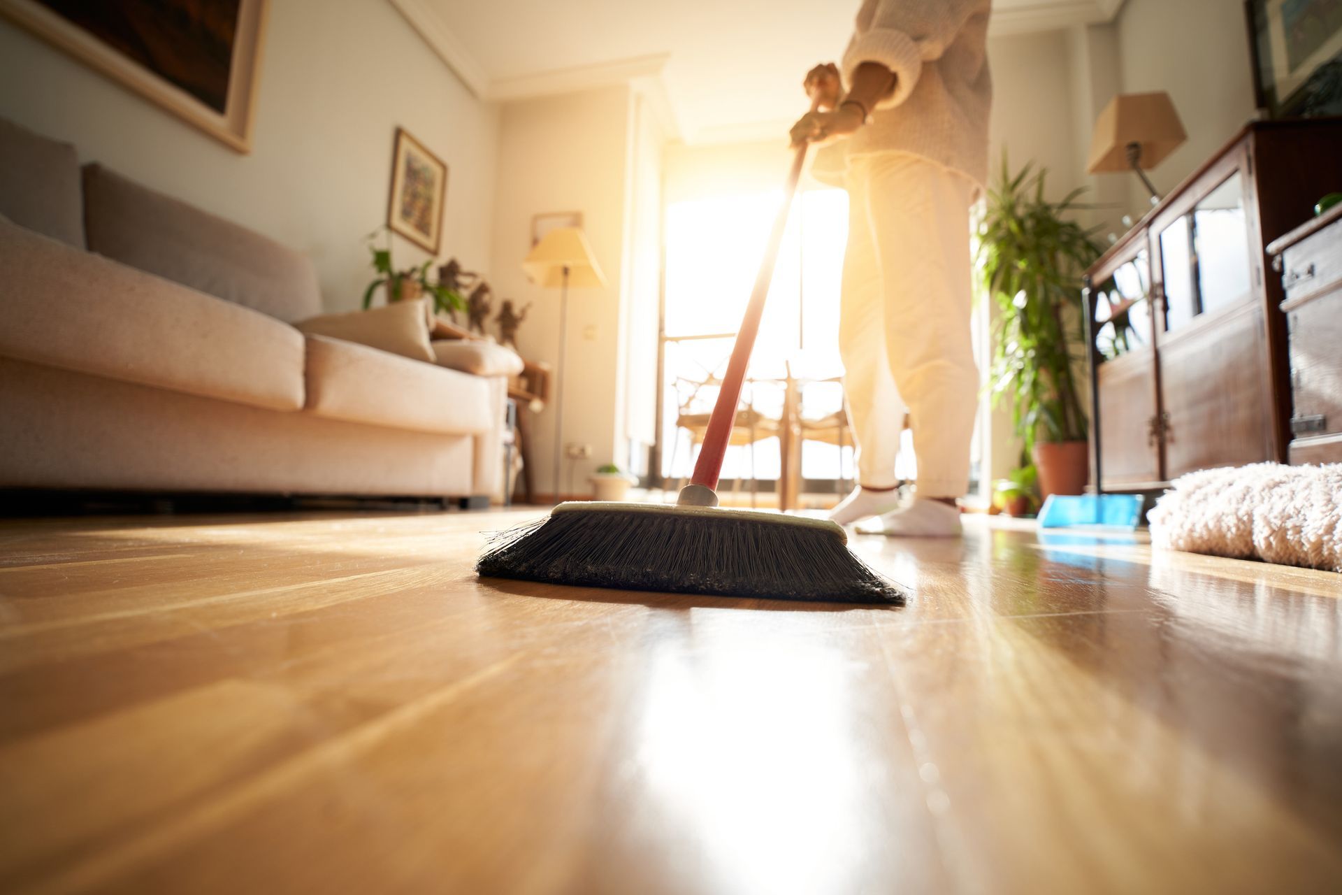 A person is mopping the floor in a living room.