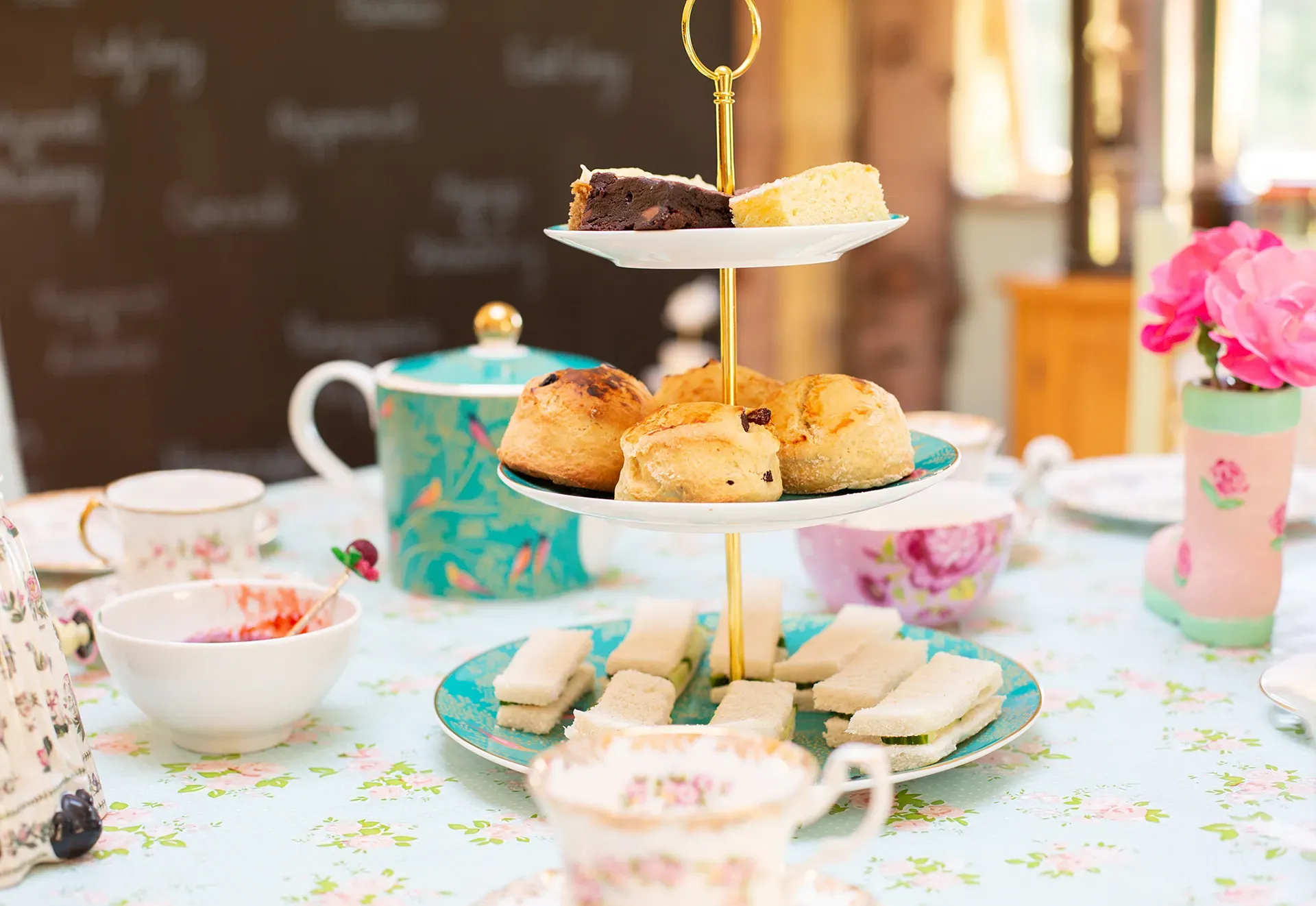 A table topped with plates of food and cups of tea.