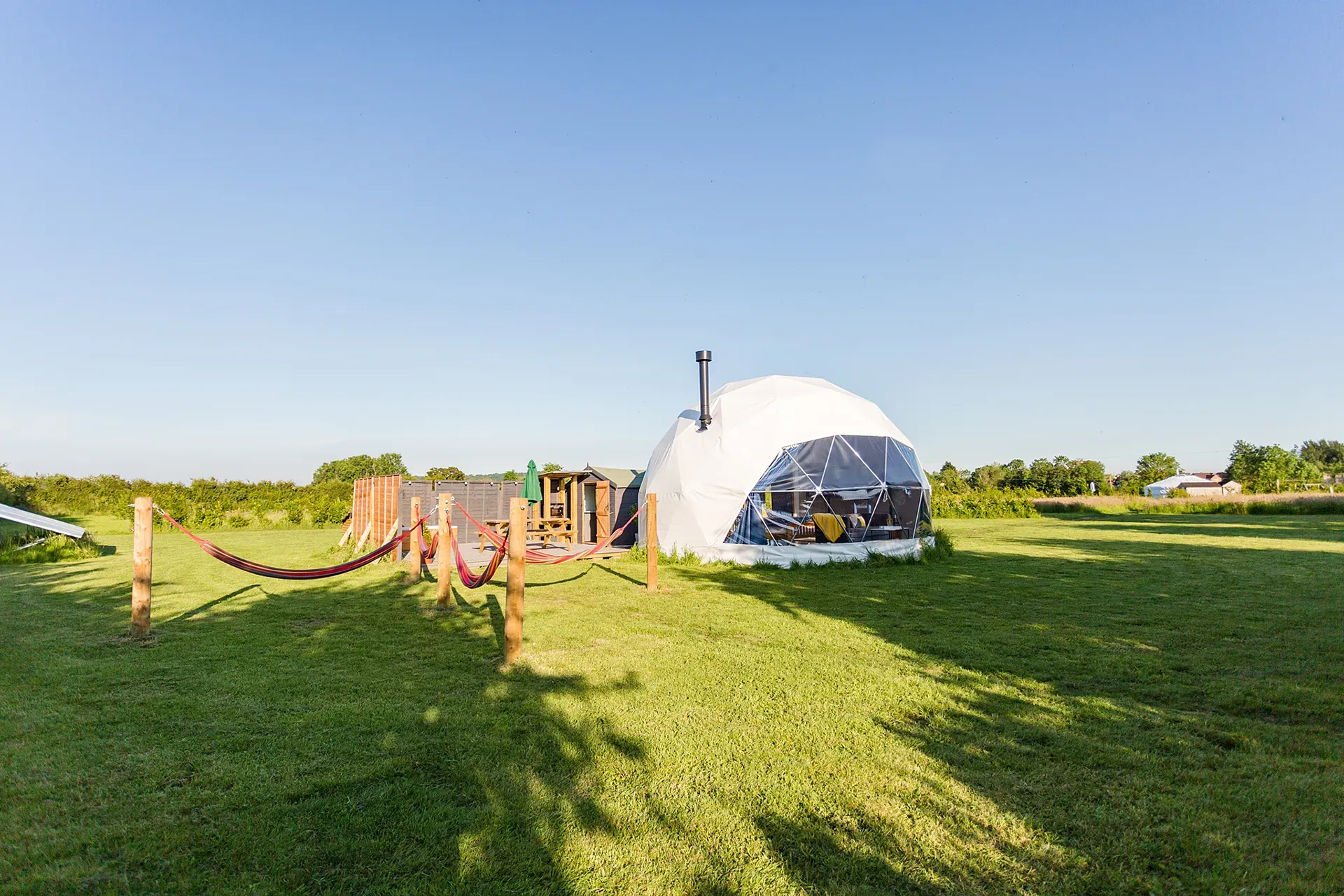 A dome tent is sitting in the middle of a grassy field.