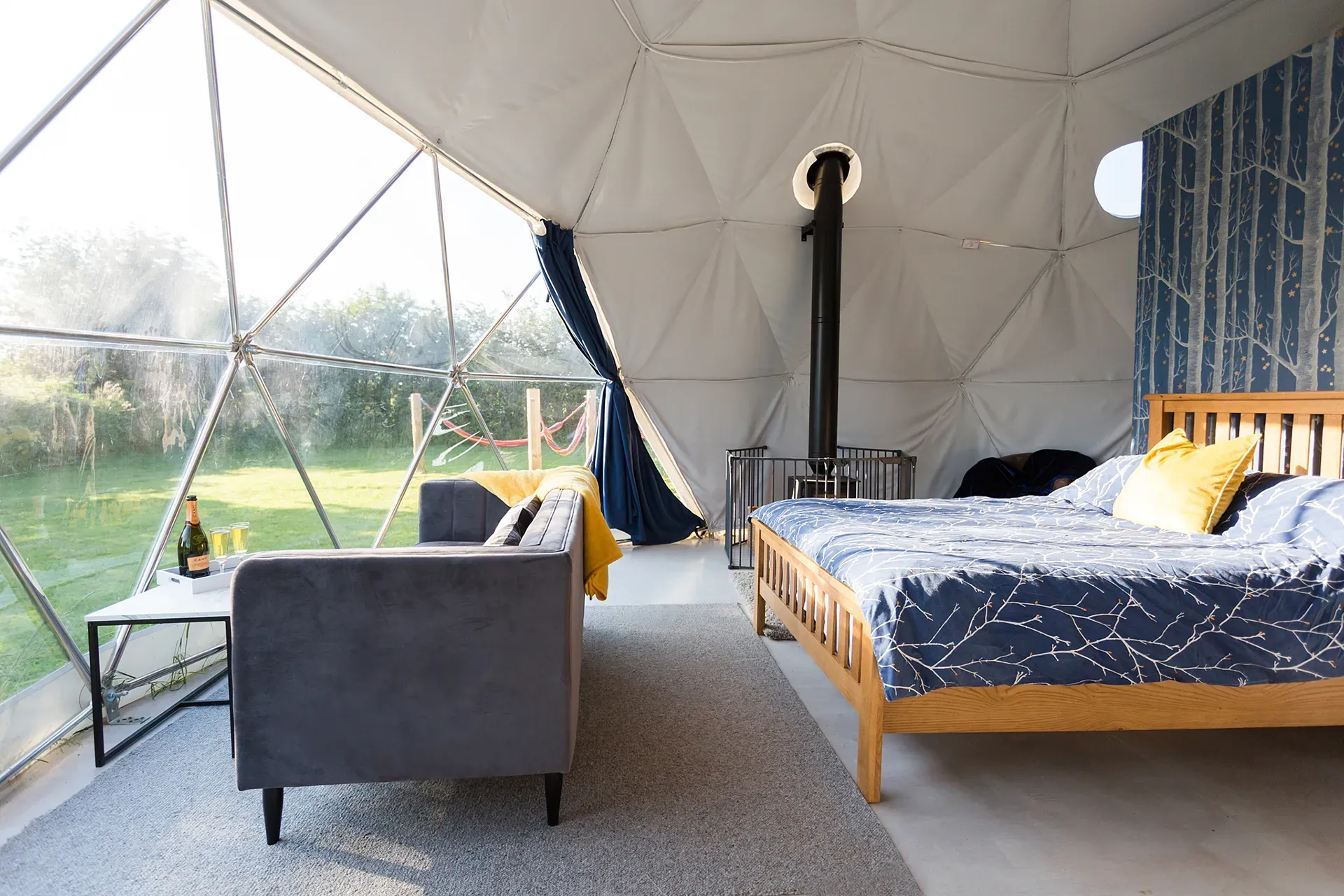 A bedroom in a dome with a bed , couch , and table.
