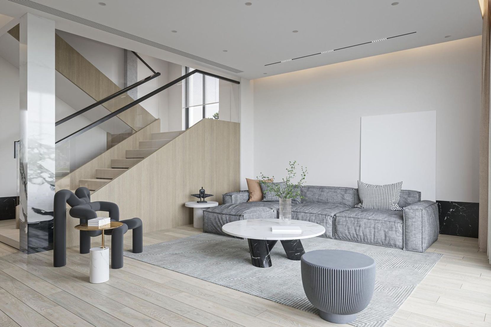 Modern minimalist living room with a gray sofa, round coffee table, stairs, and large windows