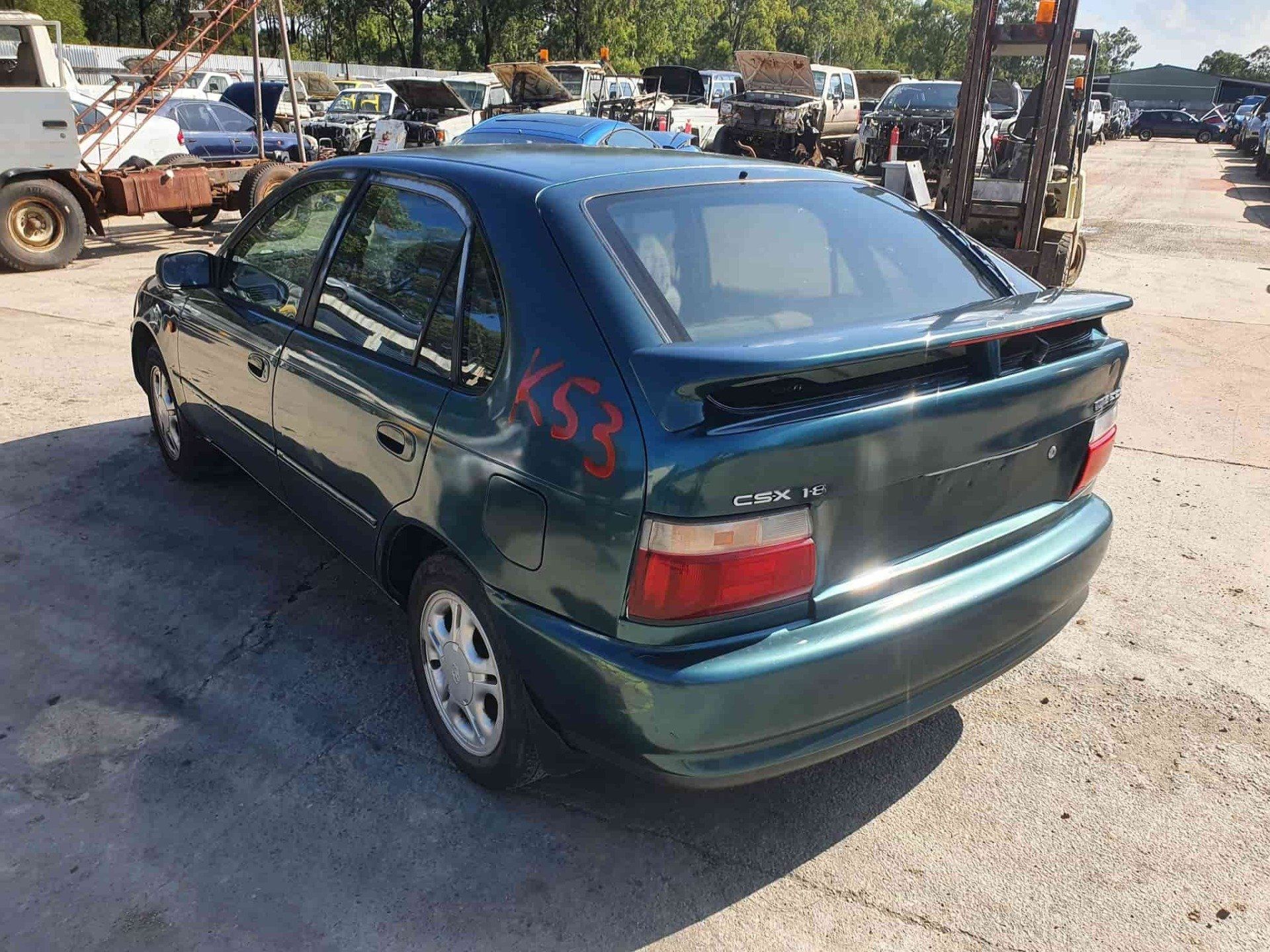 Green Car in Auto Wreckers Yard — Local Vehicle Scrapping And Repair Professionals in Bondoola, QLD
