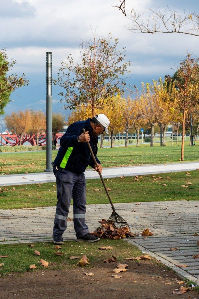 ReClean sētnieks kopj teritoriju pie ēkas