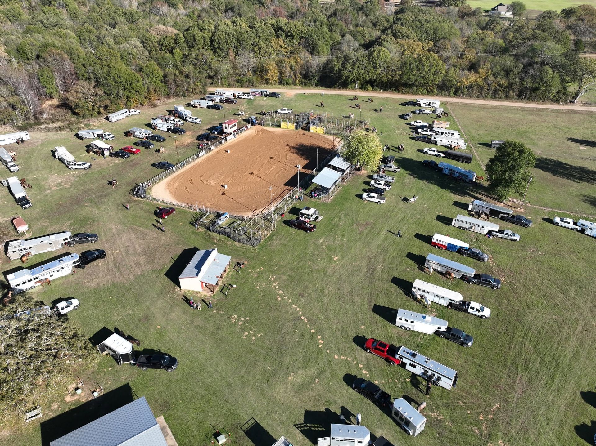 Aerial view of an outdoor event with vehicles and trailers parked across a field