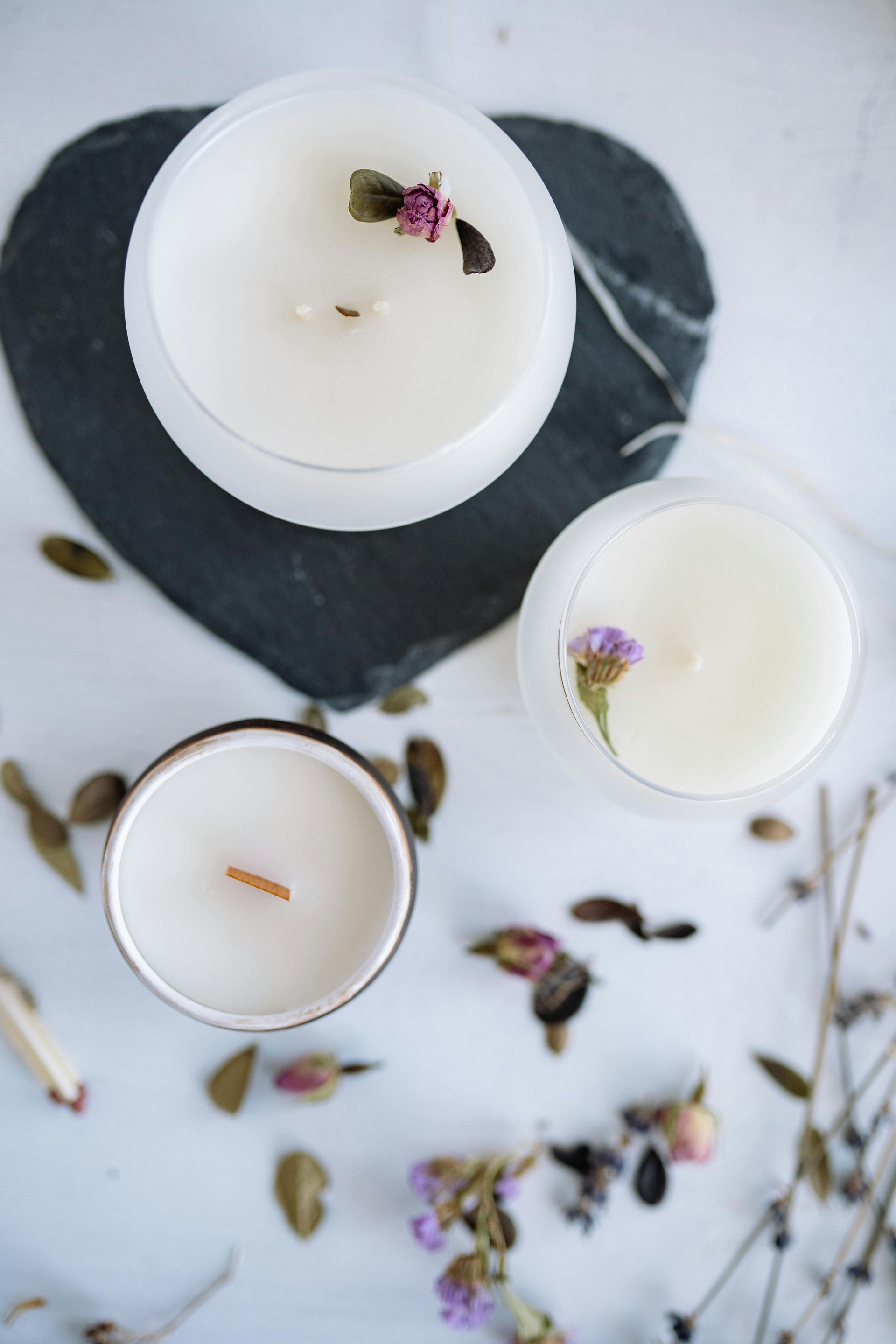 Three white candles on a marble surface