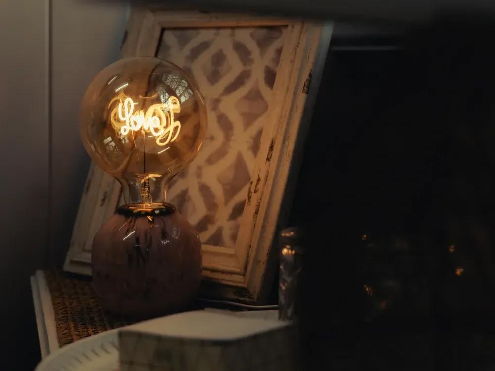 A light bulb is sitting on a table next to a picture frame.