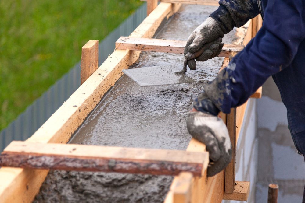 A Man is Pouring Concrete Into a Wooden Form — Core Concrete in Innisfail, QLD