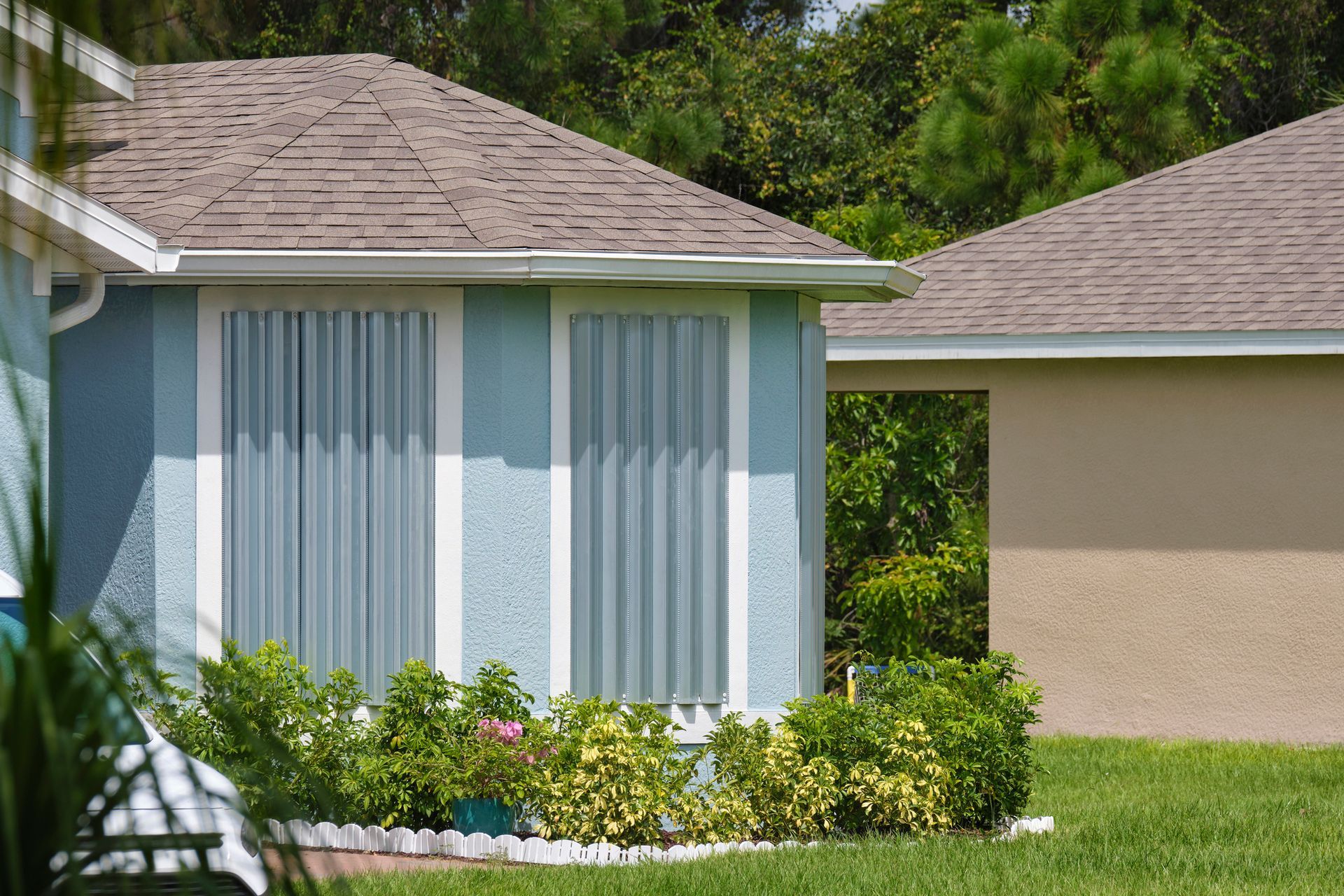 Residential building with windows covered, showcasing durable hurricane shutters for protection.