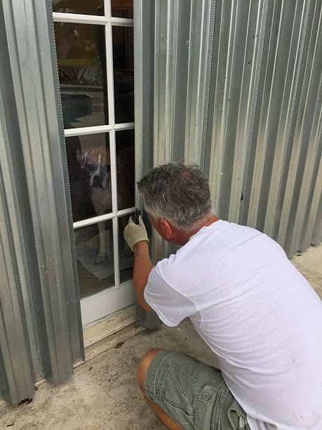 Technician fitting a window, representing professional hurricane shutters installation service.