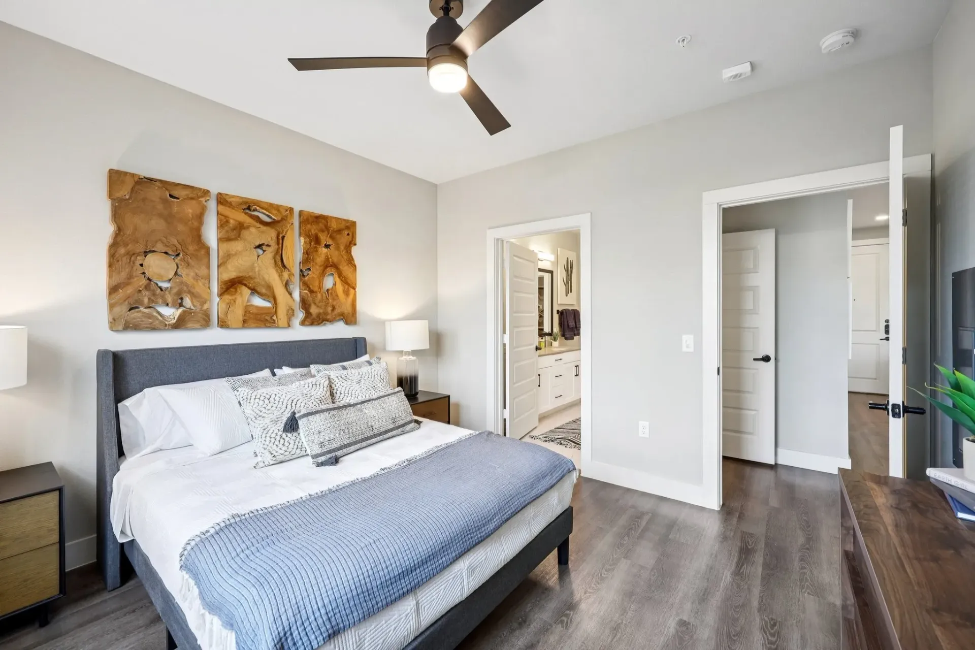 Bedroom with king bed, wall art, and view into bathroom
