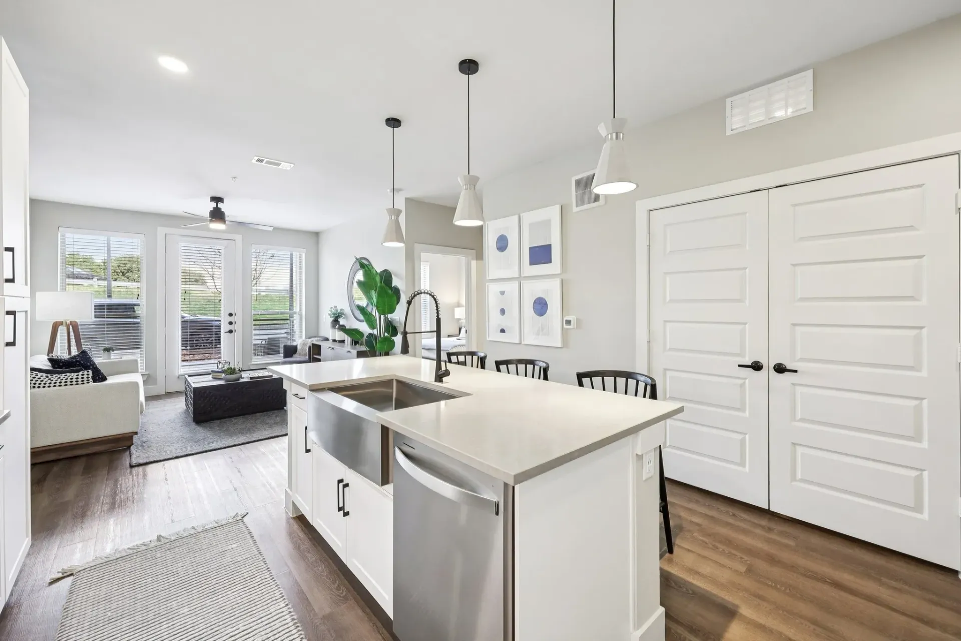 Modern kitchen with island, stainless steel appliances, and open living area.
