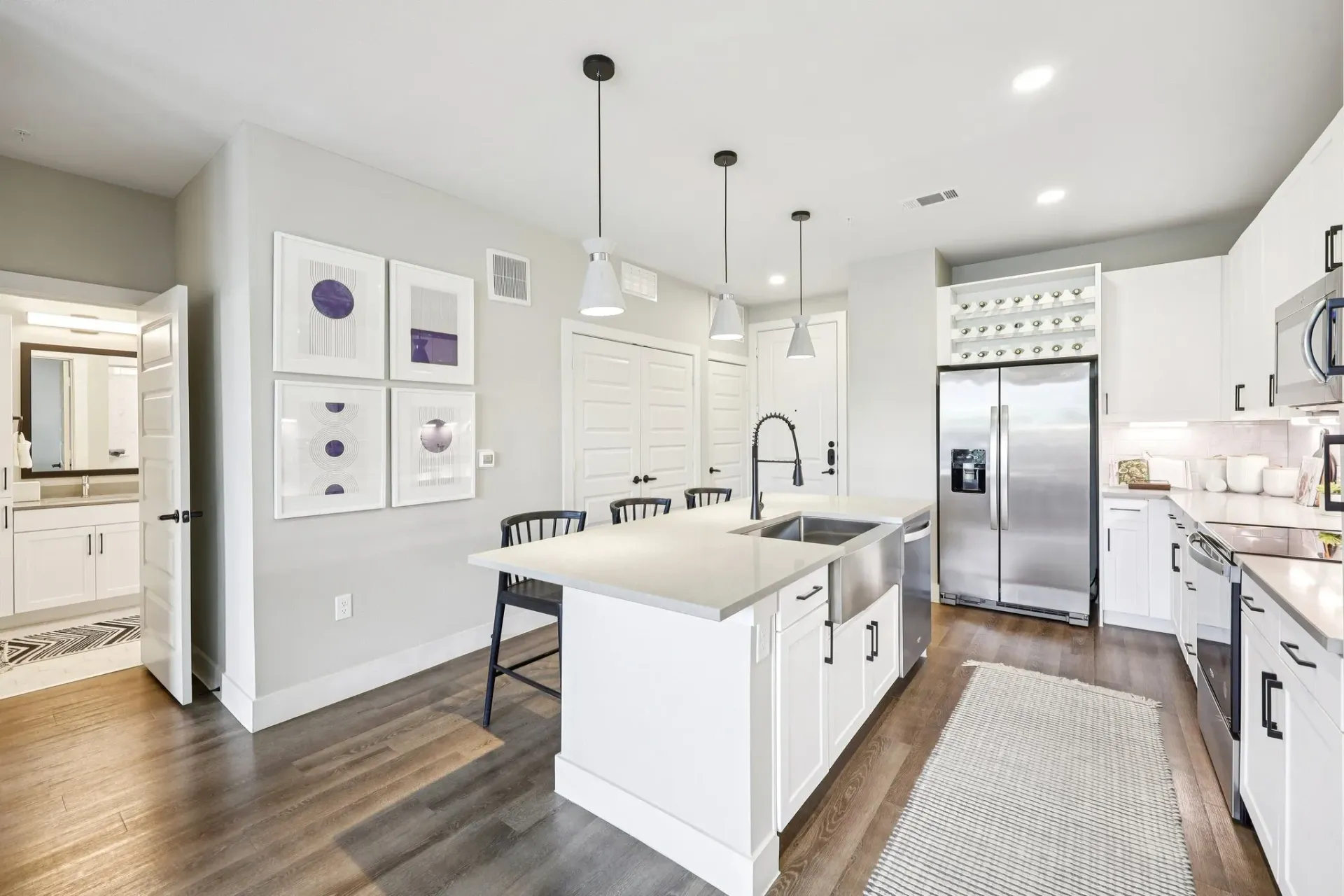 Modern kitchen with white cabinets, stainless steel appliances, and an island.