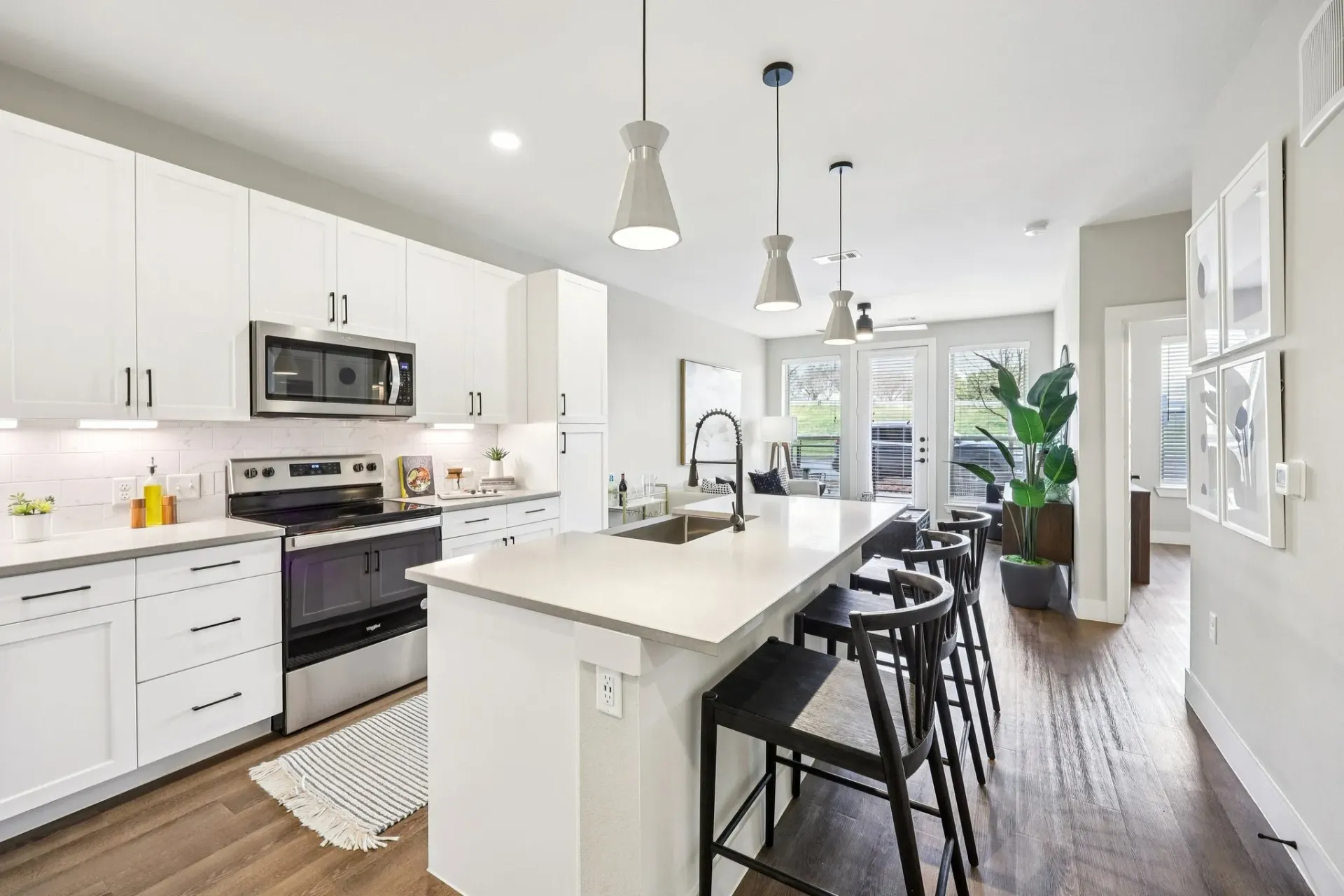 Modern kitchen with white cabinets, stainless steel appliances, and a large island with seating.