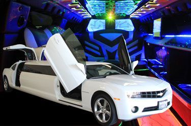 White Chevrolet Camaro limousine with doors open, interior lights up in blue, black, and green.