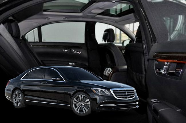 Black sedan with open doors; interior view reveals leather seats and a sunroof.