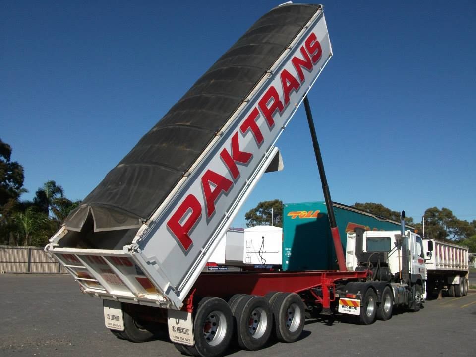 A large dump truck with its bed raised, labeled 