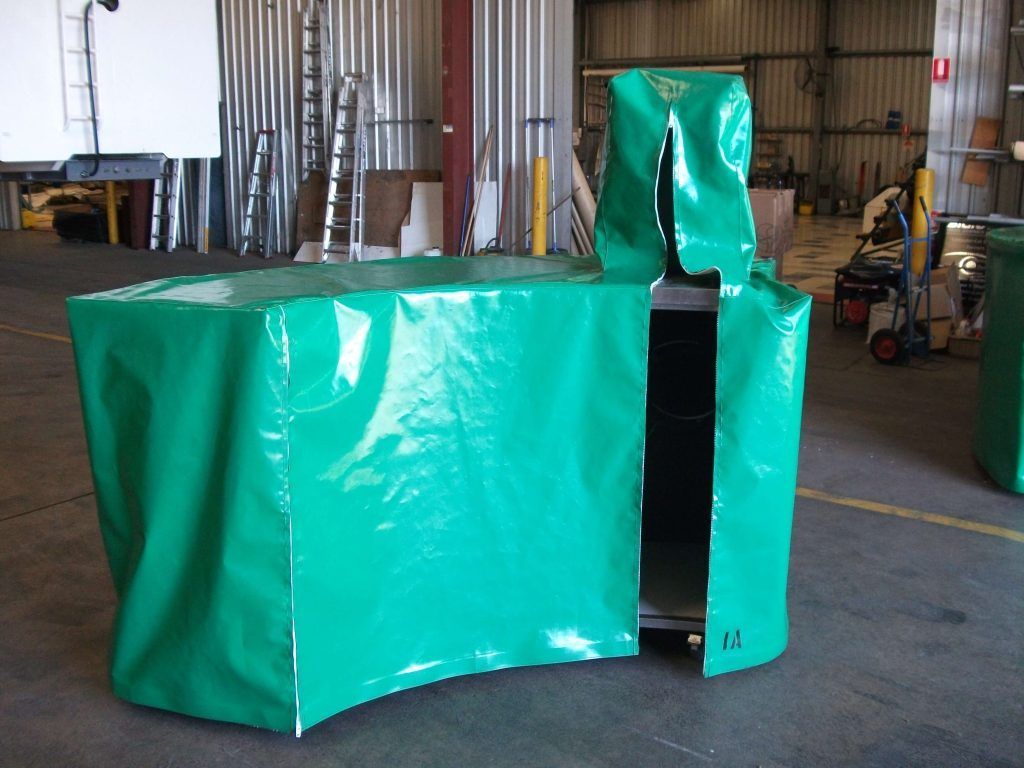 Green vinyl covering a metal structure with a tall, open section, indoors.