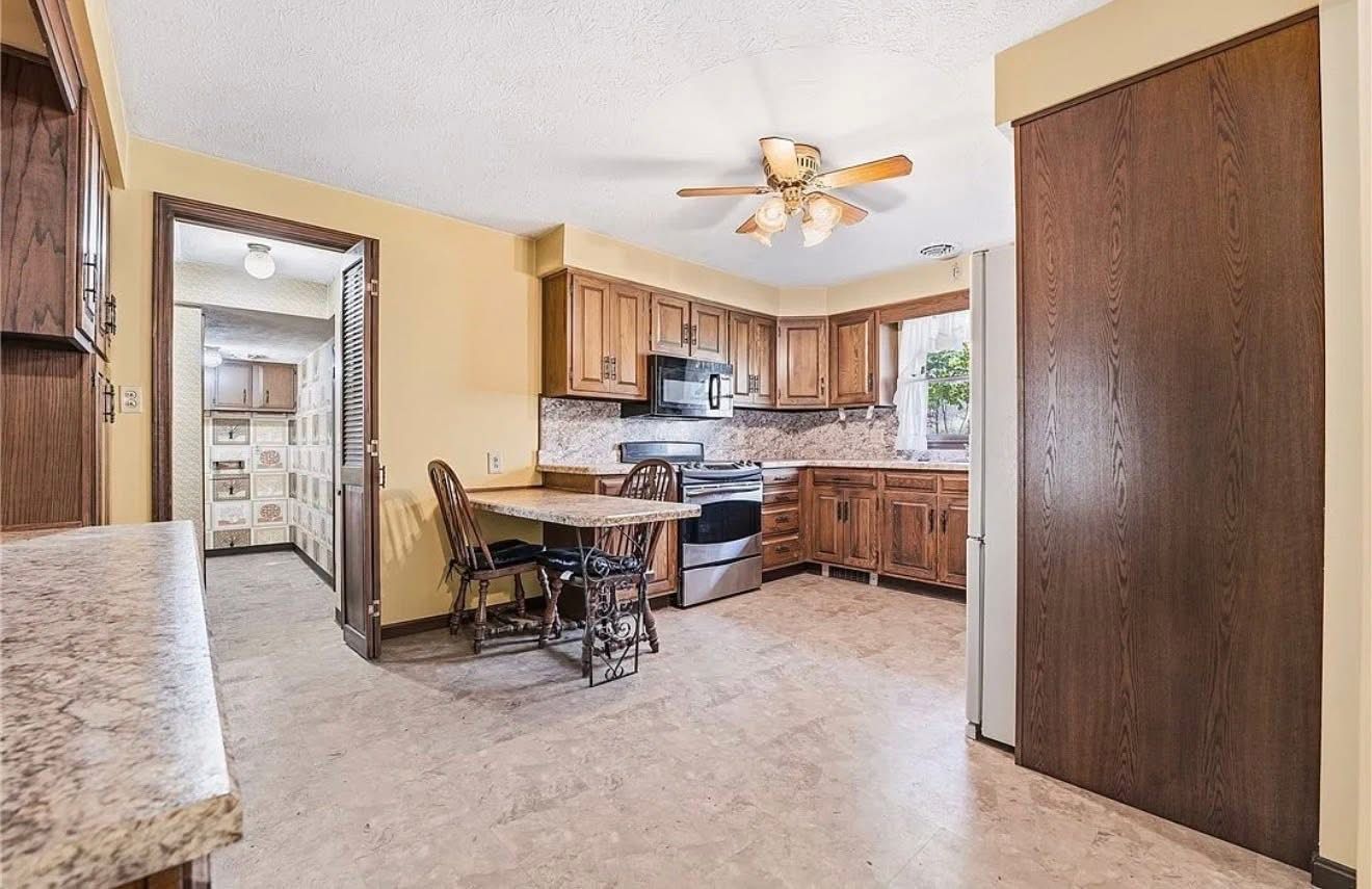 Kitchen and dining area with wood cabinets, white appliances, ceiling fan, and tiled floor