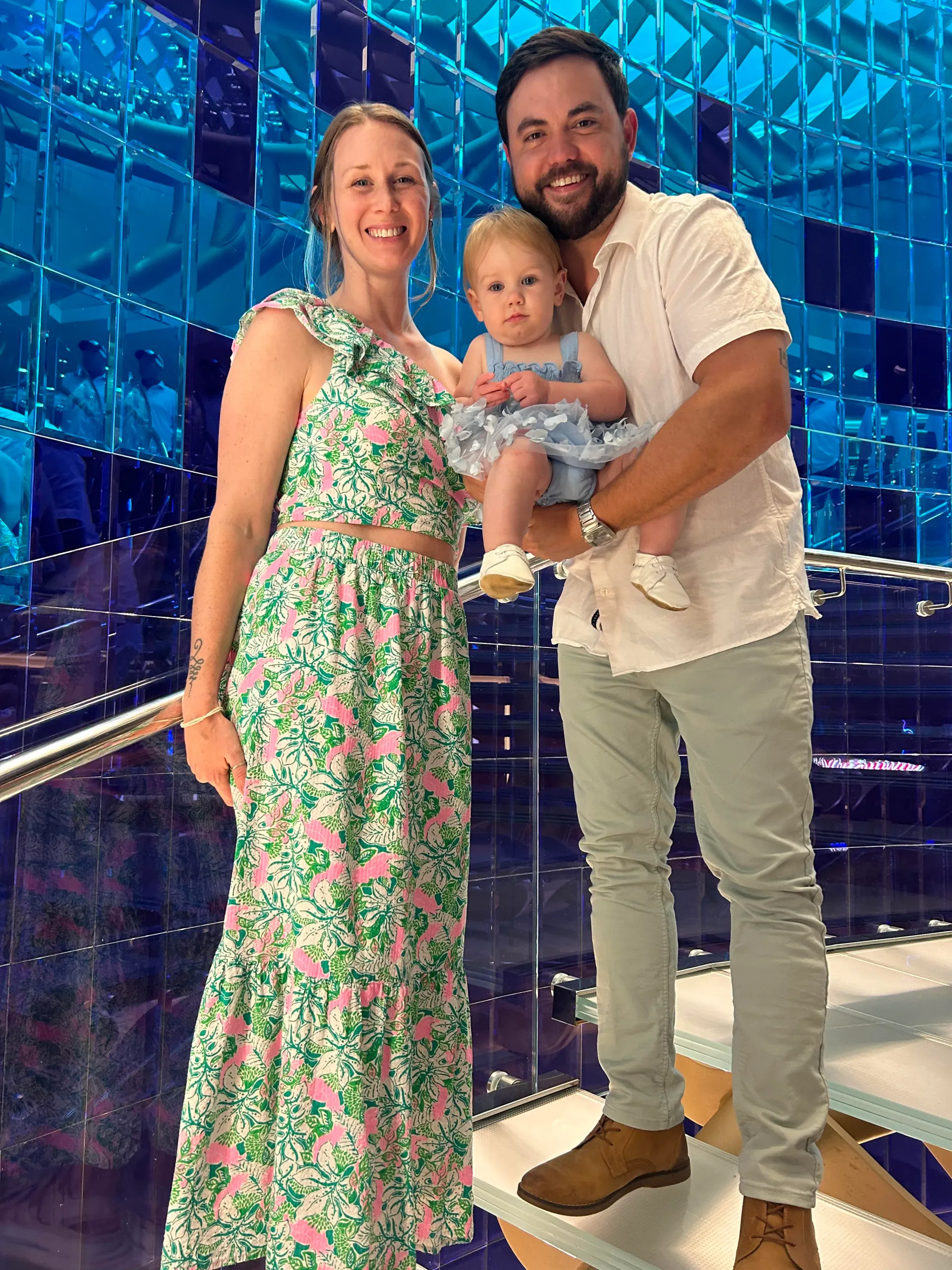 A man and woman are standing next to each other holding a baby.