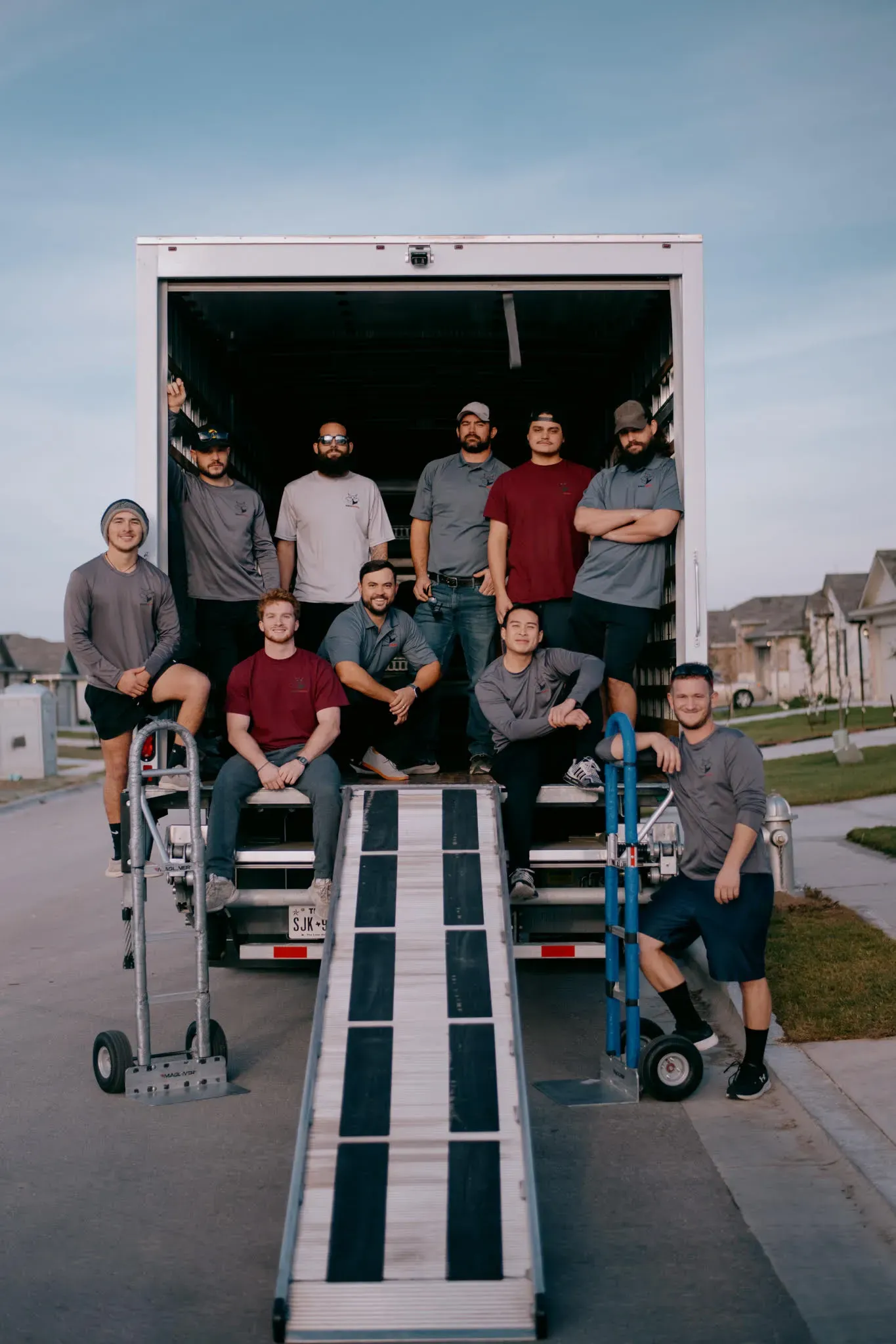 A group of men are standing in front of a moving truck.