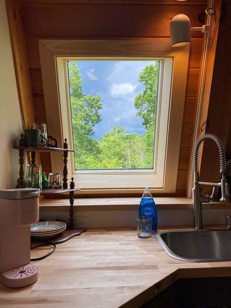 A kitchen with a sink and a window with a view of trees