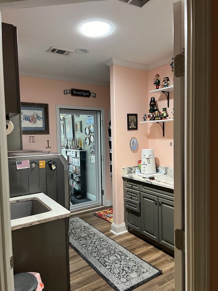 A kitchen with a sink, cabinets, and a rug